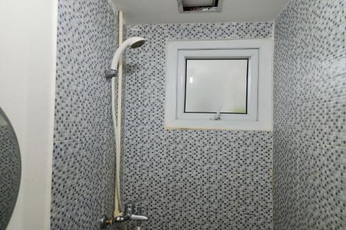a bathroom with a shower with a window at Barata Hotel Near Bandara Soekarno Hatta in Teko