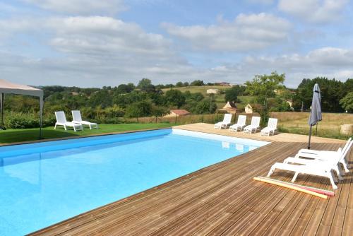 une piscine avec des chaises blanches et une terrasse dans l'établissement Les Granges, à Marquay