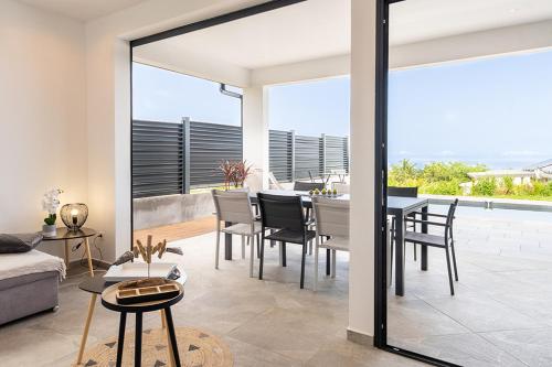 a living room with a table and chairs and a dining room at KAY SE MI in Case-Pilote