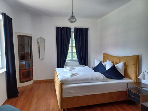 a bedroom with a large bed with blue pillows at Ferienwohnung 'Bergidylle' - Zu Fuß auf die Loipe und den Berg, nur wenige Minuten ins Skigebiet in Bayrischzell