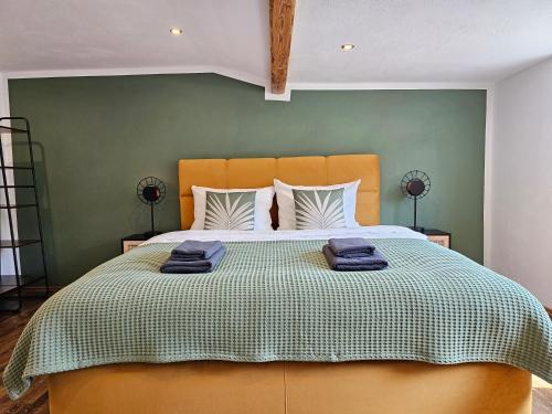 ein Schlafzimmer mit einem großen Bett und einer grünen Wand in der Unterkunft Tucan - Rooftop Terrace with View, BBQ, PS4+Stream in Marburg an der Lahn