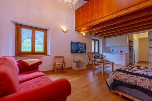 a living room with a red couch and a table at Casa Gialla - Happy Rentals in Pugerna