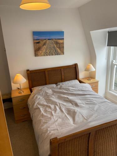 ein Schlafzimmer mit einem großen Bett mit zwei Nachttischen in der Unterkunft City centre Rooftop apartment alongside river Suir in Waterford