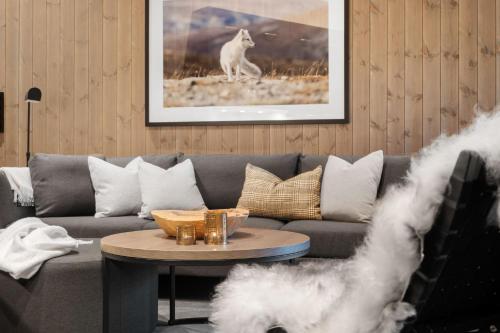a living room with a grey couch and a table at Yttersvingen Kvitfjell in Kvitfjell