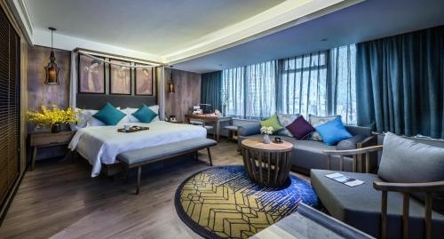 a hotel room with a bed and a couch at True Go S Hotel - Shenzhen Convention and Exhibition Center Union Square Branch in Shenzhen