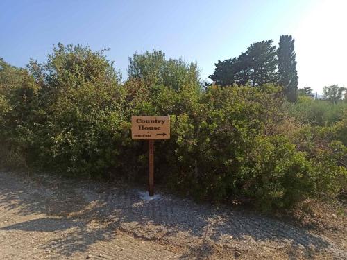a sign that says country houses in front of bushes at Country House in Karlovasi
