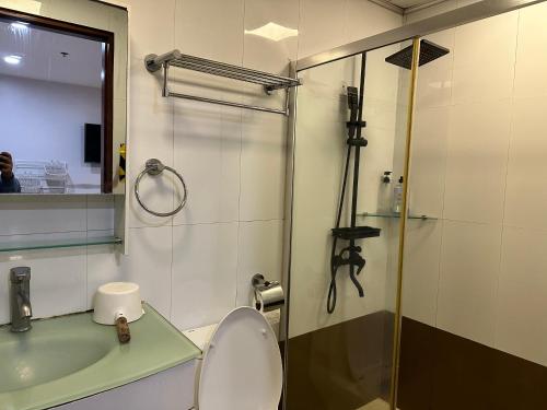 a bathroom with a toilet and a sink and a shower at Ann’s Suites 2BR Mega1 w/parking in Baguio