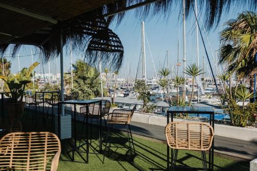 a patio with chairs and tables and a view of a marina at Hotel Puerto Sherry in El Puerto de Santa María