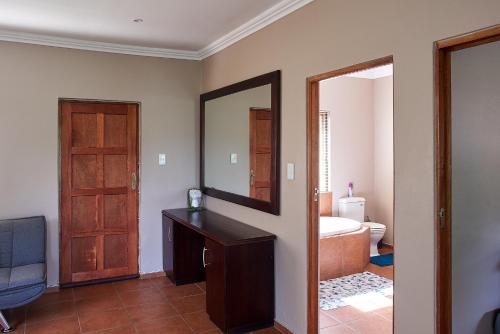 Cette chambre comprend une salle de bains pourvue d'un miroir et d'un lavabo. dans l'établissement Eden Self Catering Clarens, à Clarens