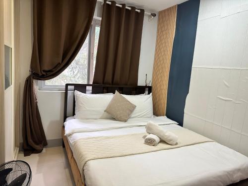 a bedroom with a bed with a stuffed animal on it at Ann’s Suites 2BR Mega1 w/parking in Baguio