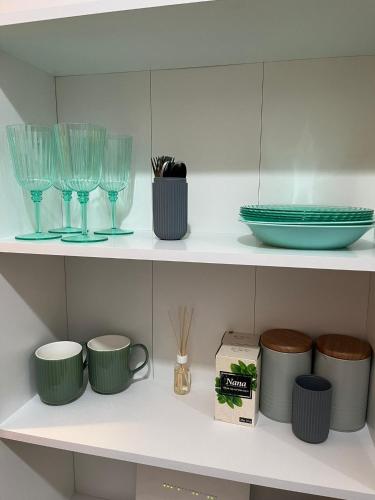 a shelf with glasses and other items on it at Room Glorija 2 in Pančevo
