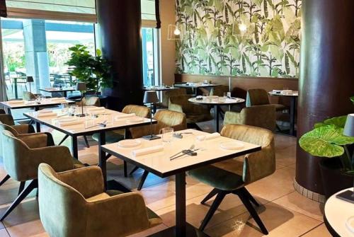 a restaurant with tables and chairs in a room at Ramada Plaza by Wyndham Milano in Milan
