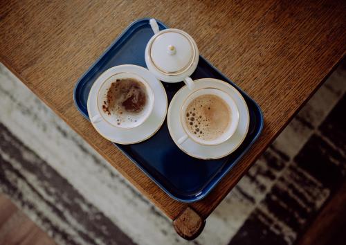 two cups of coffee on a blue tray on a table at Kuzmanovi dvori in Štitar