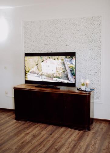 a flat screen tv sitting on a stand in a room at Kuzmanovi dvori in Štitar