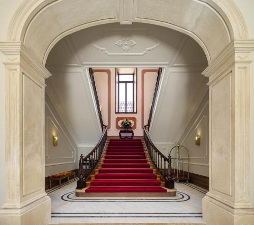 a stairway with a red carpeted staircase with a stair case at MS Collection Aveiro - Palacete Valdemouro in Aveiro
