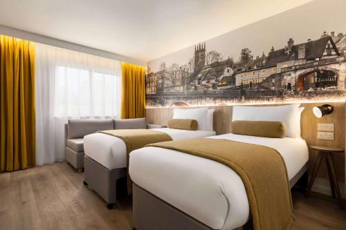 a hotel room with three beds and a couch at Super 8 by Wyndham Chester East in Chester