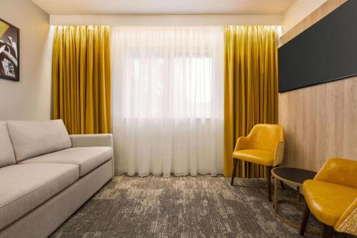 a living room with a couch and yellow curtains at Super 8 by Wyndham Chester East in Chester
