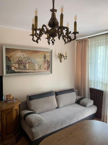 sala de estar con sofá y lámpara de araña en Konstancin-Jeziorna Wilanowska en Konstancin-Jeziorna