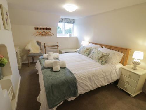 a bedroom with a bed with two stuffed animals on it at Grove Cottage in Leominster