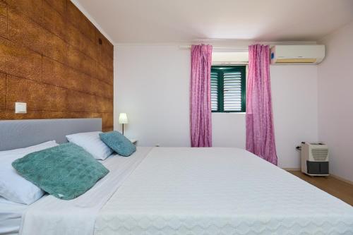 een slaapkamer met een groot wit bed en paarse gordijnen bij Just a step to the Old city gates in Dubrovnik