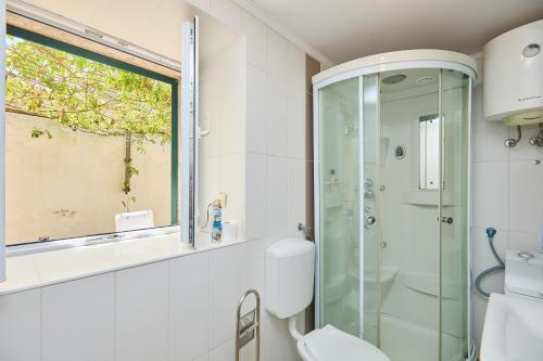 een badkamer met een glazen douche en een toilet bij Just a step to the Old city gates in Dubrovnik