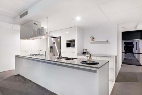 a white kitchen with a sink and a counter at Circle on Cavill - Self Contained & Privately Managed - Wow Stay in Gold Coast