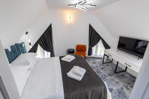a bedroom with a bed and a flat screen tv at D&D Relax SPA Bucovina in Câmpulung Moldovenesc