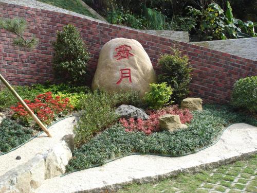 a rock with writing on it in a garden at Jihead Villa in Xinpu