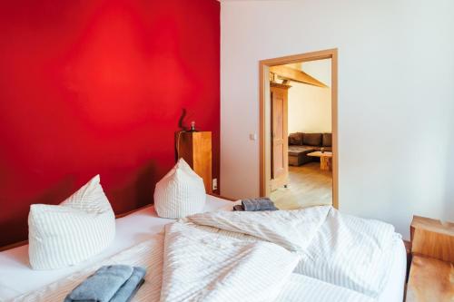 een slaapkamer met 2 bedden en een rode muur bij Alte Kass in Neidlingen