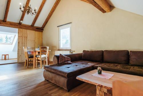 a living room with a brown couch and a table at Alte Kass in Neidlingen