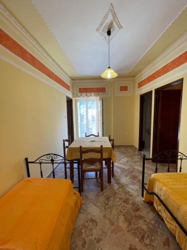a room with two beds and a table in it at U Curtigliu apartment in Realmonte