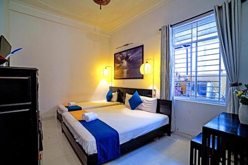 1 dormitorio con cama y ventana grande en Hoi An Viet House Homestay, en Hoi An