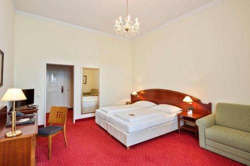 ein Schlafzimmer mit einem großen weißen Bett und einem Stuhl in der Unterkunft Austria Trend Hotel Schloss Wilhelminenberg Wien in Wien
