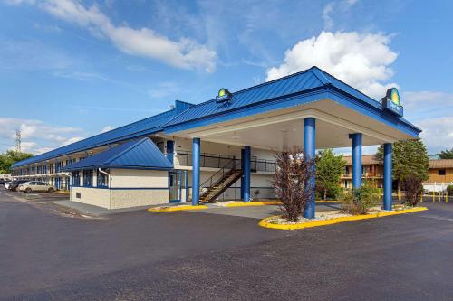 un edificio con tetto blu e un parcheggio di Days Inn by Wyndham Knoxville North a Knoxville