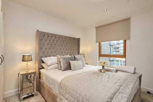 ein Schlafzimmer mit einem großen Bett und einem Fenster in der Unterkunft Deluxe River View Apt & Free Parking! in Leeds