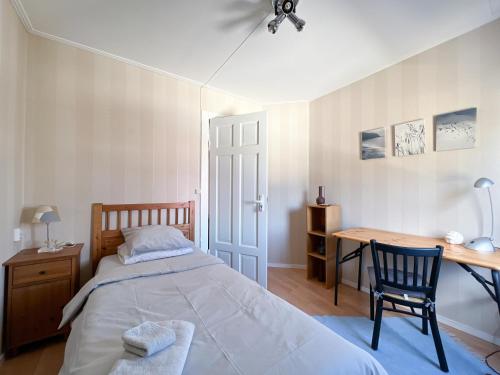 um quarto com uma cama, uma secretária e uma mesa em Långträsk Apartments Villa em Långträsk