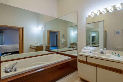 a bathroom with two sinks and a large mirror at Southcape Resort Mashpee a Ramada by Wyndham in Mashpee