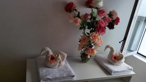 due asciugamani e un vaso con fiori su un tavolo di SGA a Trieste