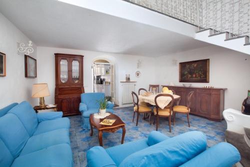 a living room with blue furniture and a table at Estate4home- La casa del Maresciallo in Positano