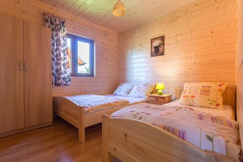 a bedroom with two beds in a wooden cabin at PANORAMA Domki i Pokoje Nad Jeziorem 660-332-576 in Polańczyk