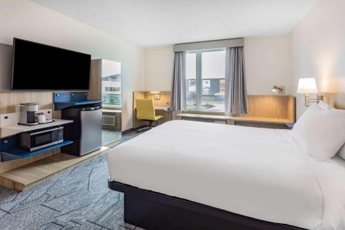 a hotel room with a large bed and a flat screen tv at Microtel Inn & Suites by Wyndham Summerside in Summerside