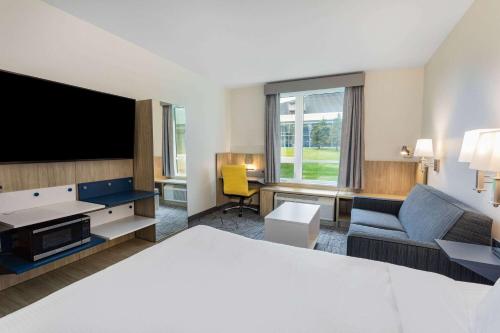 a hotel room with a bed and a flat screen tv at Microtel Inn & Suites by Wyndham Summerside in Summerside