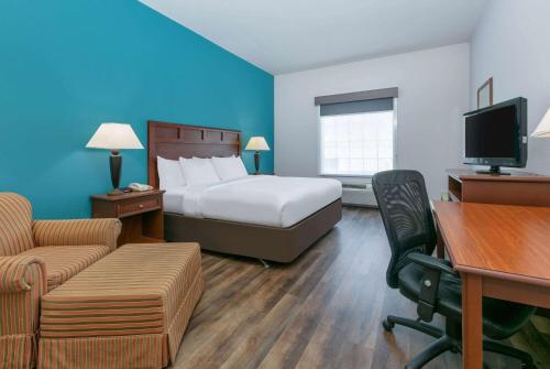 a hotel room with a bed and a desk at Baymont Inn & Suites by Wyndham Glen Rose in Glen Rose