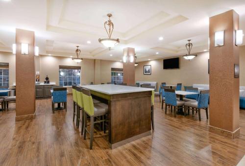 a large room with a bar with chairs and tables at Baymont Inn & Suites by Wyndham Glen Rose in Glen Rose