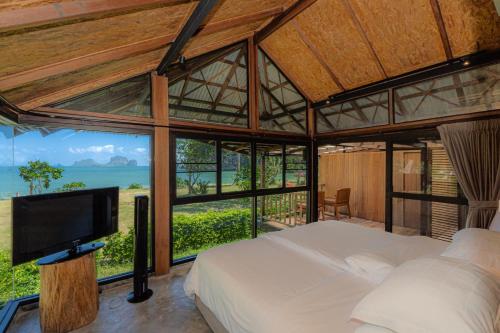sypialnia z łóżkiem, telewizorem i oknami w obiekcie Tinidee Hideaway Tonsai Beach Krabi - SHA Extra Plus w mieście Tonsai Beach