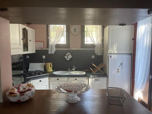 uma cozinha com uma mesa e um frigorífico branco em Maison Du Lac em Marcillac-la-Croisille
