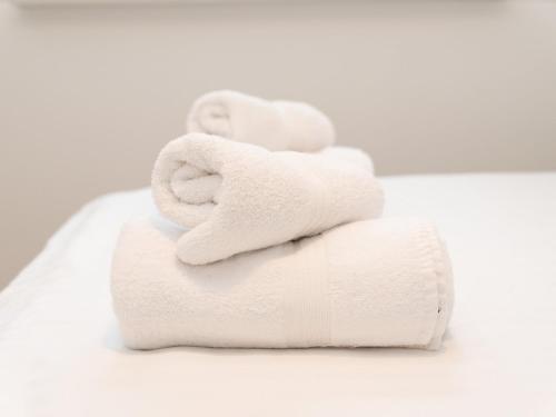 a stack of white towels sitting on top of a sink at Pass the Keys Fresh and Stylish Central Flat With Parking and Garden in London