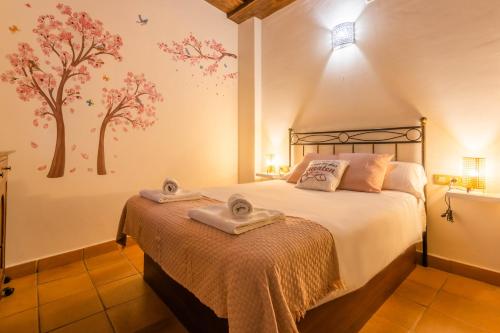 a bedroom with a bed with towels on it at Macarena Muralla Encantada in Seville