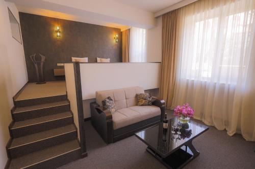 a living room with a couch and a stair case at Cascade Hotel in Yerevan
