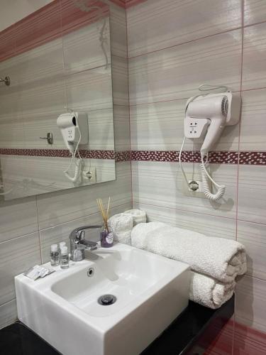 ein Badezimmer mit einem weißen Waschbecken und einem Spiegel in der Unterkunft Hotel Selfo in Gjirokastër